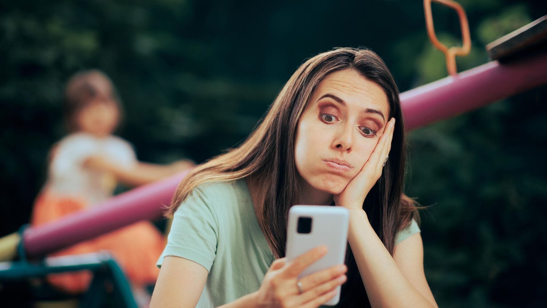 madre con un grupo de whatsapp del colegio en el parque 