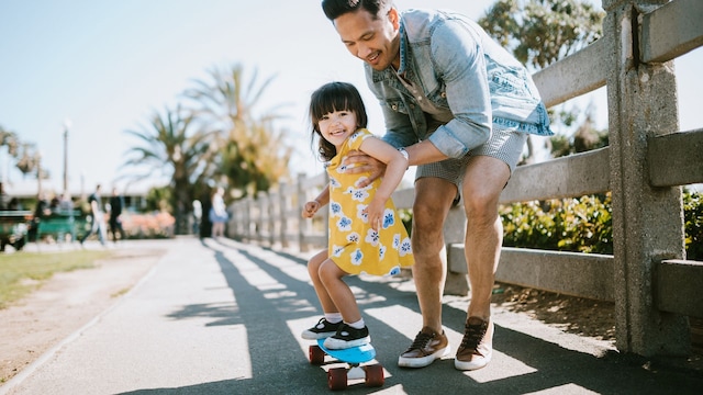Padre ayudando a patinar a su hija en California