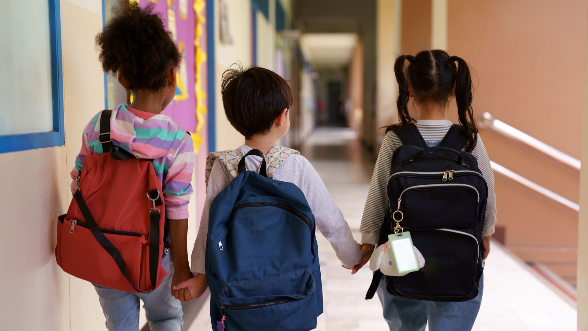 Niños con mochila en los pasillos del colegio