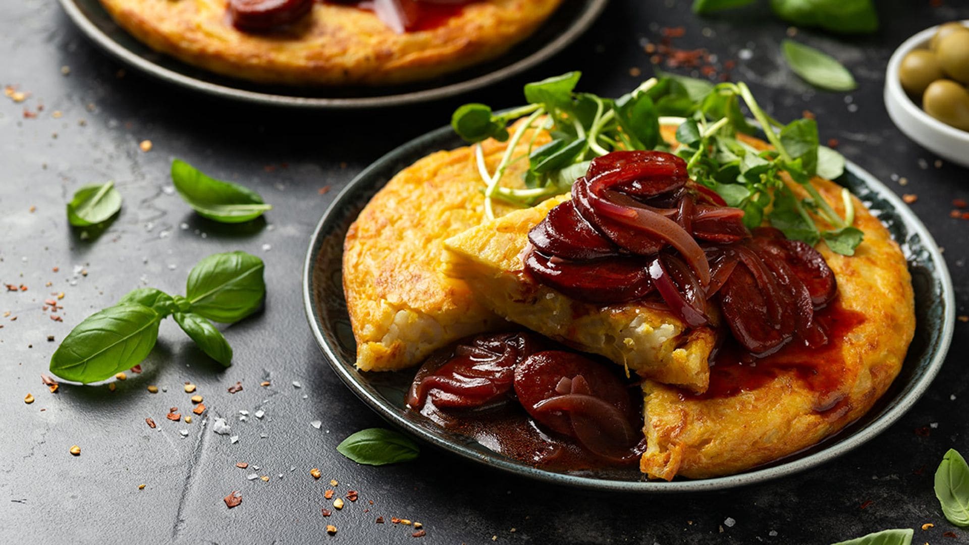 Tortilla de patata en salsa de chorizo picante y cebolla morada