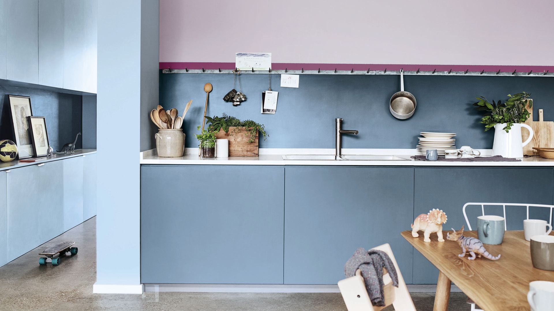 Cocina con muebles azules y paredes lavanda