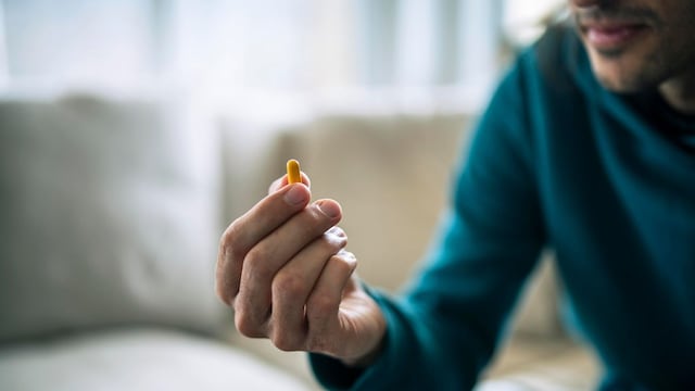 un hombre observa una pastilla