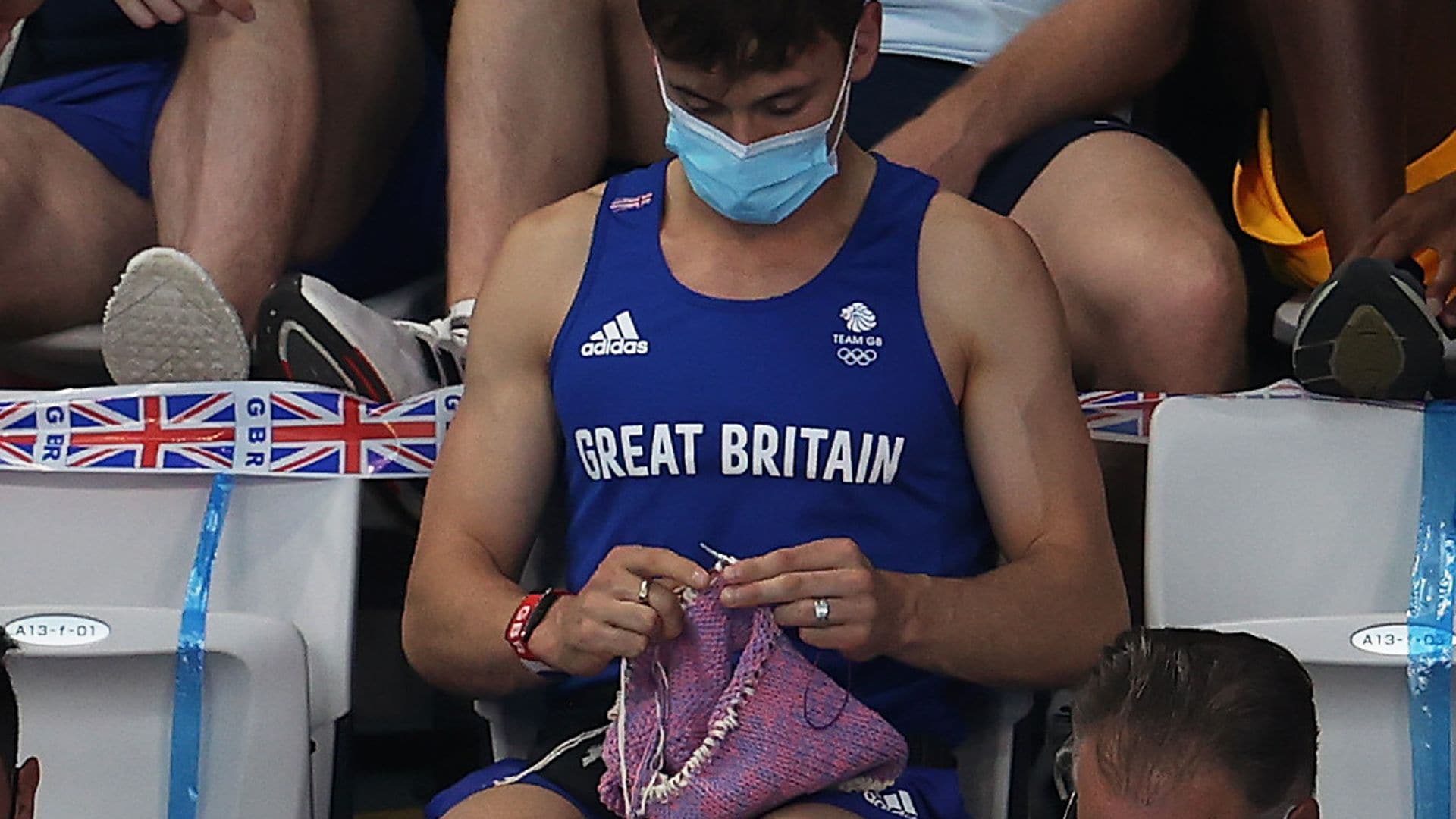 Tom Daley de Gran Bretaña teje mientras observa la final femenina de trampolín de 3m en los Juegos Olímpicos de Tokio 2020 