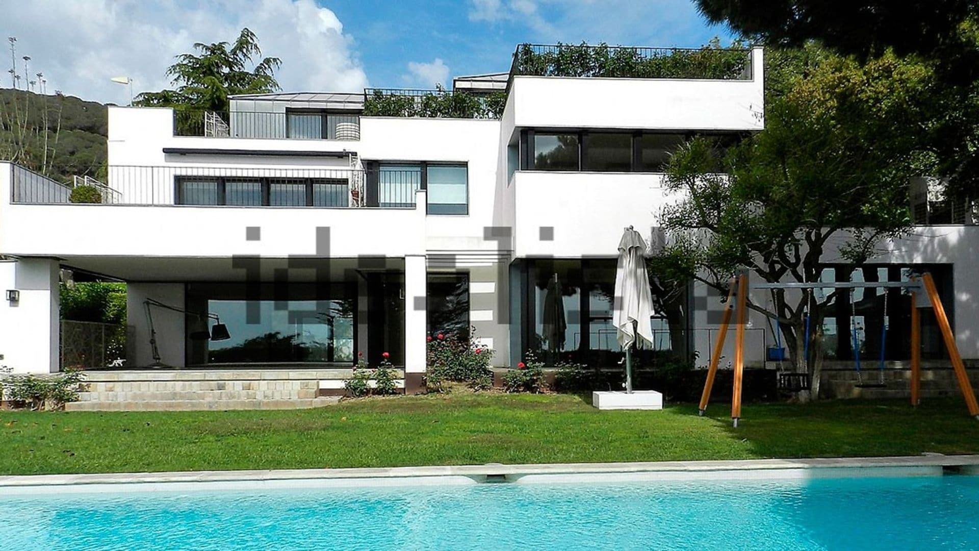 Casa Pep Guardiola con piscina y jardín de fachada blanca y carpintería negra