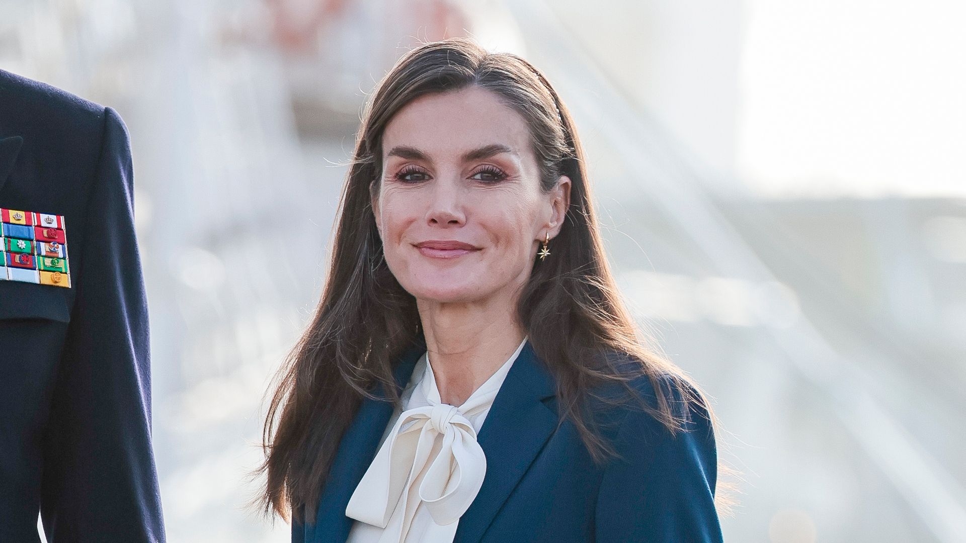 La reina Letizia, con traje de chaqueta en azul 'navy' y diadema joya para la despedida de Elcano