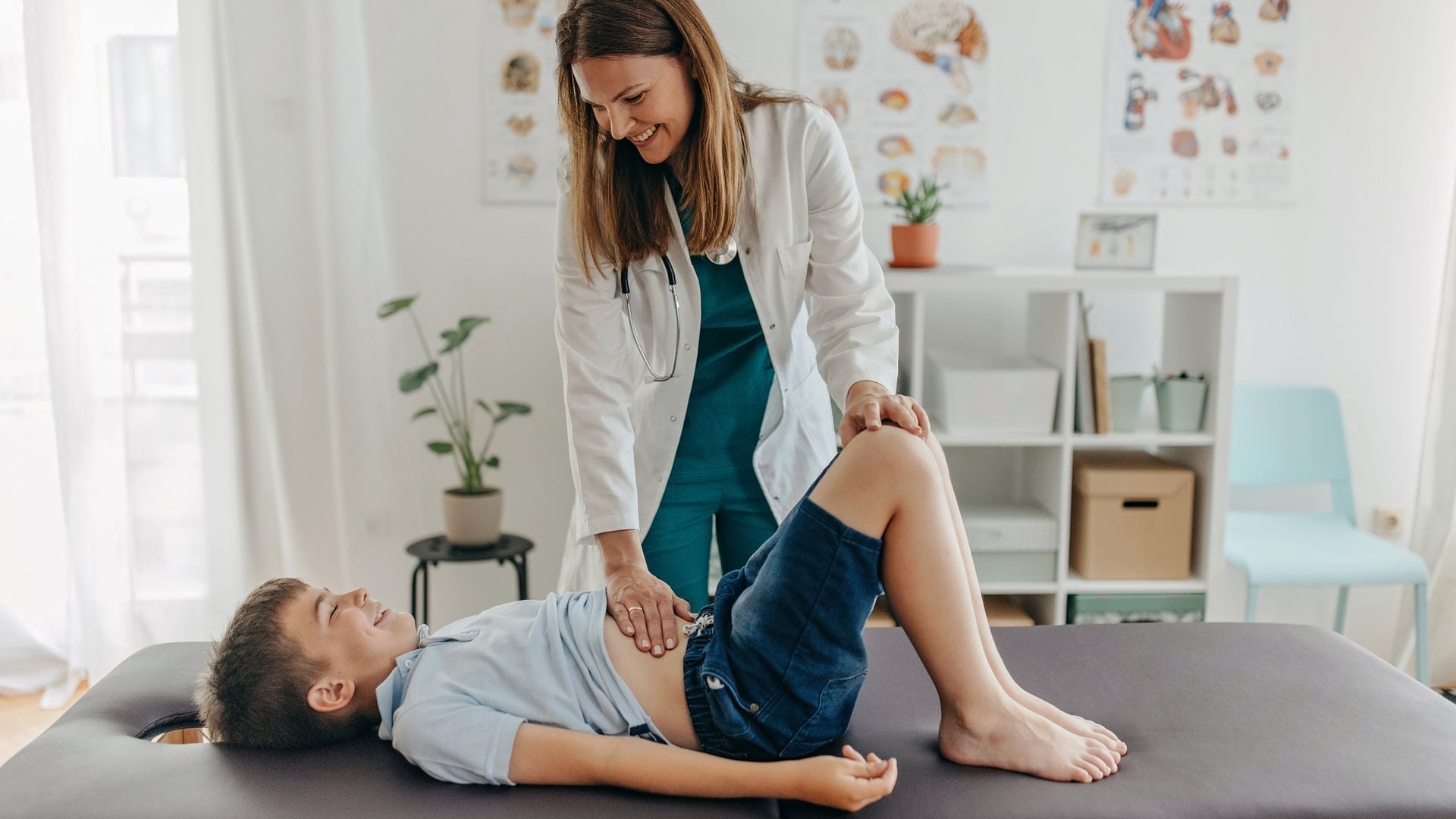 Doctora explora a un niño con dolor de estómago