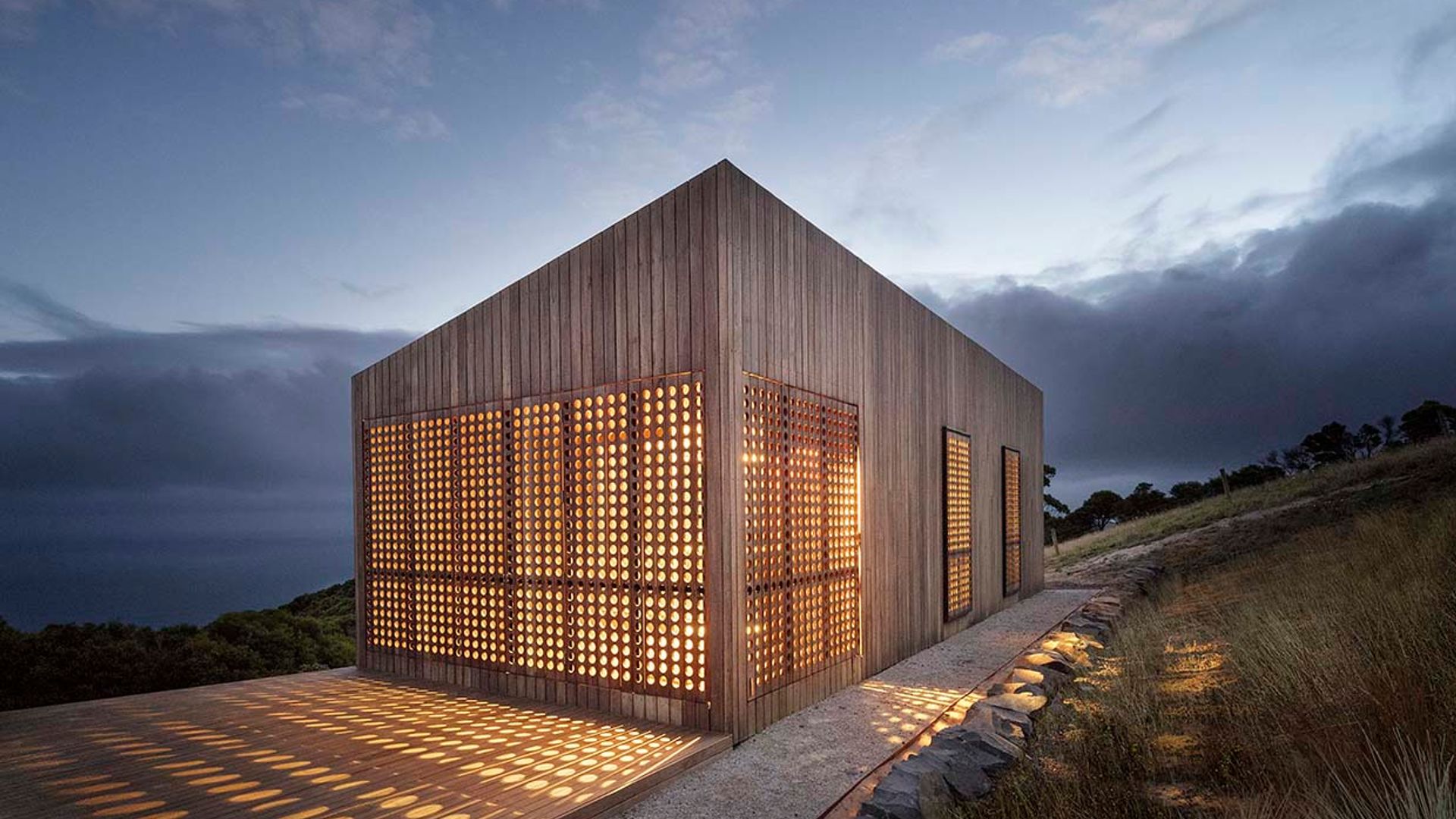 Una casa de madera bajo las estrellas concebida como una caja de luz