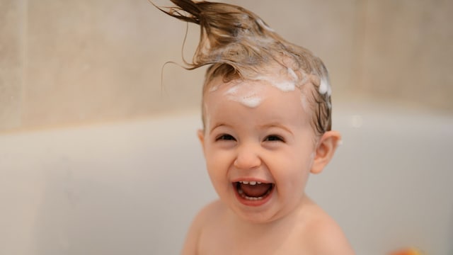 Niño ríe en la bañera