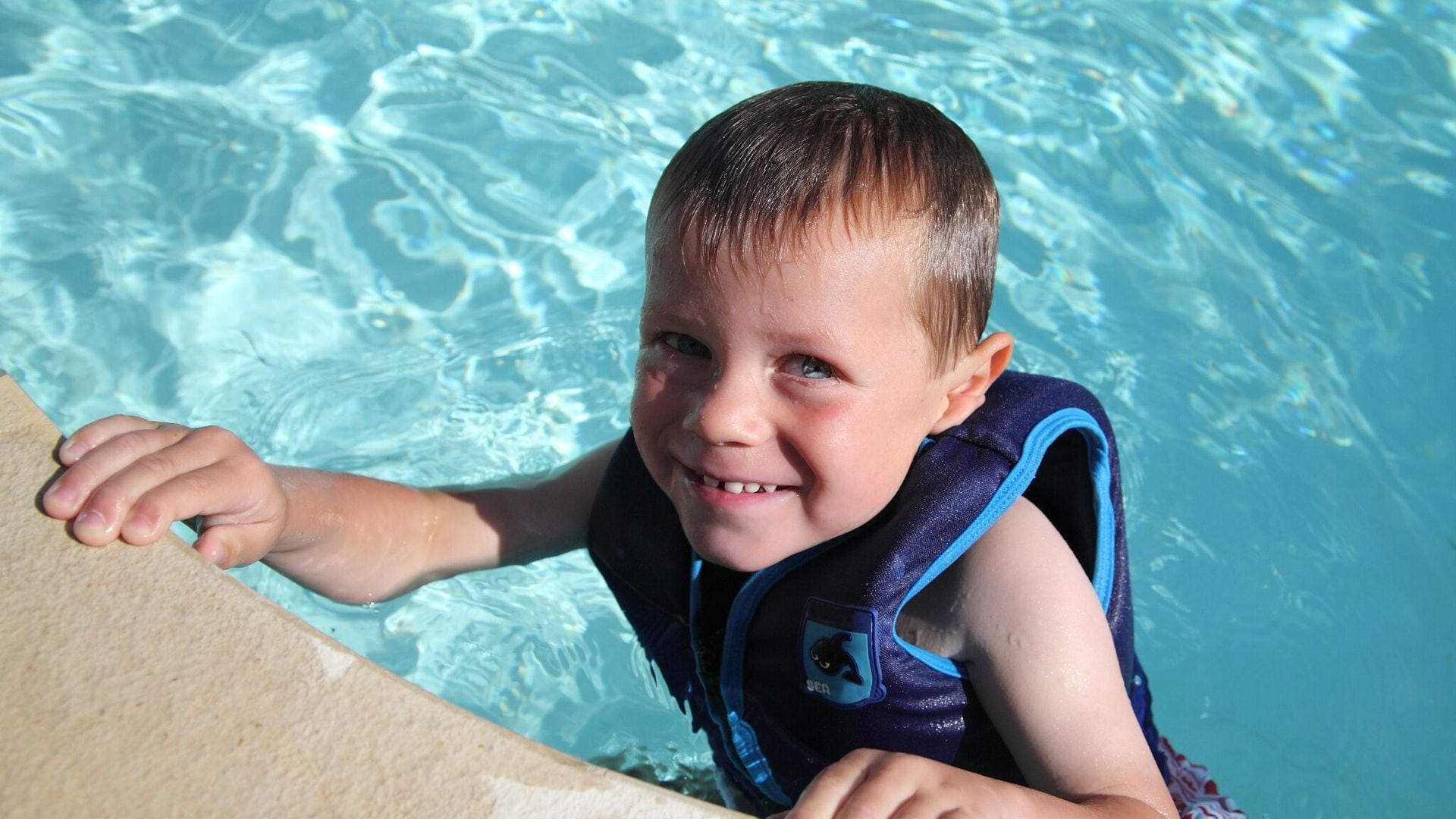 ni o en la piscina con chaleco de flotaci n