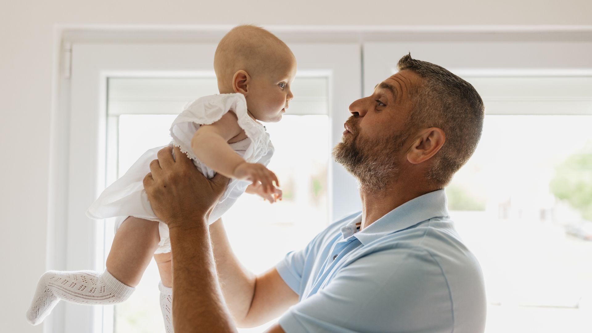 Un hombre aúpa a un bebé