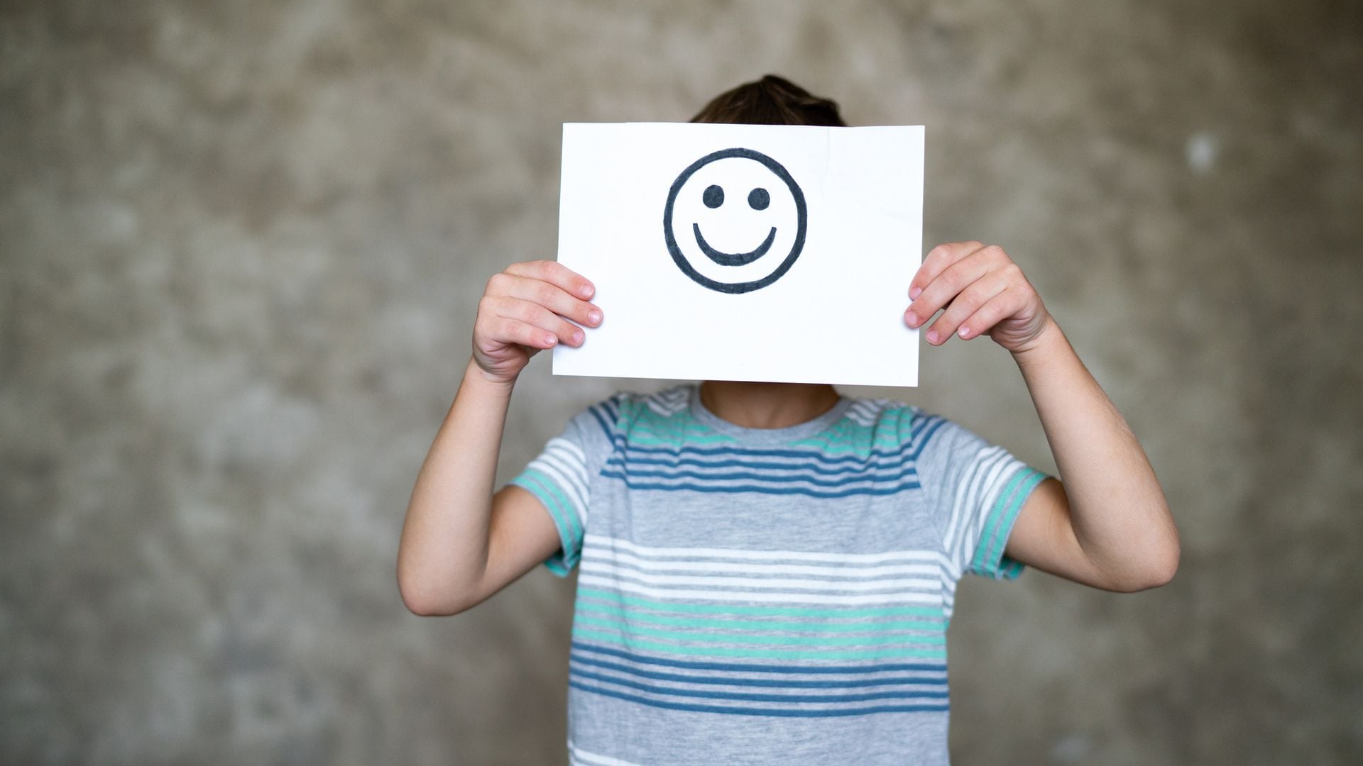 Niño con dibujo de cara sonriente