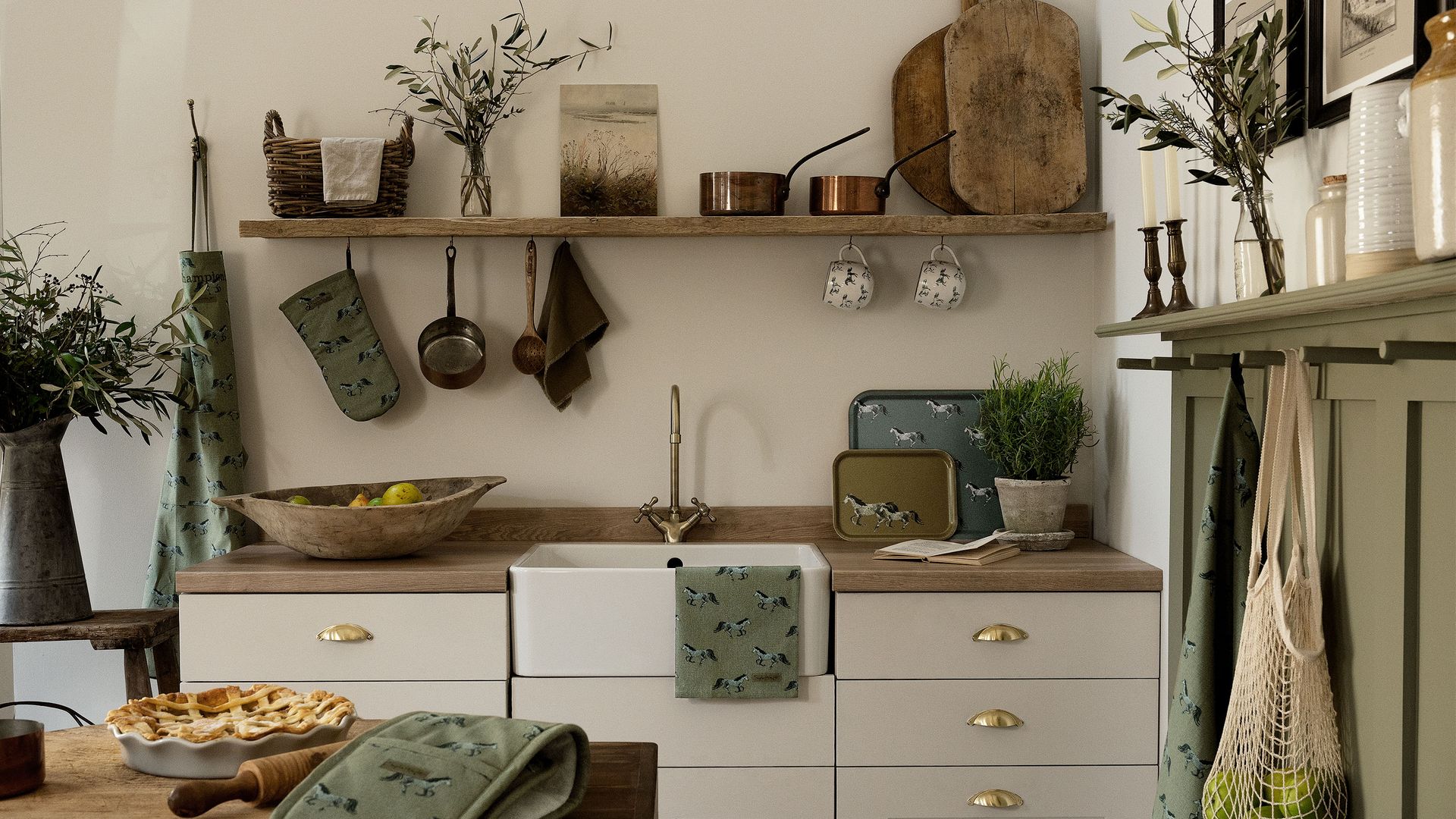 Cocina blanca con tiradores de concha, balda de madera y accesorios a la vista