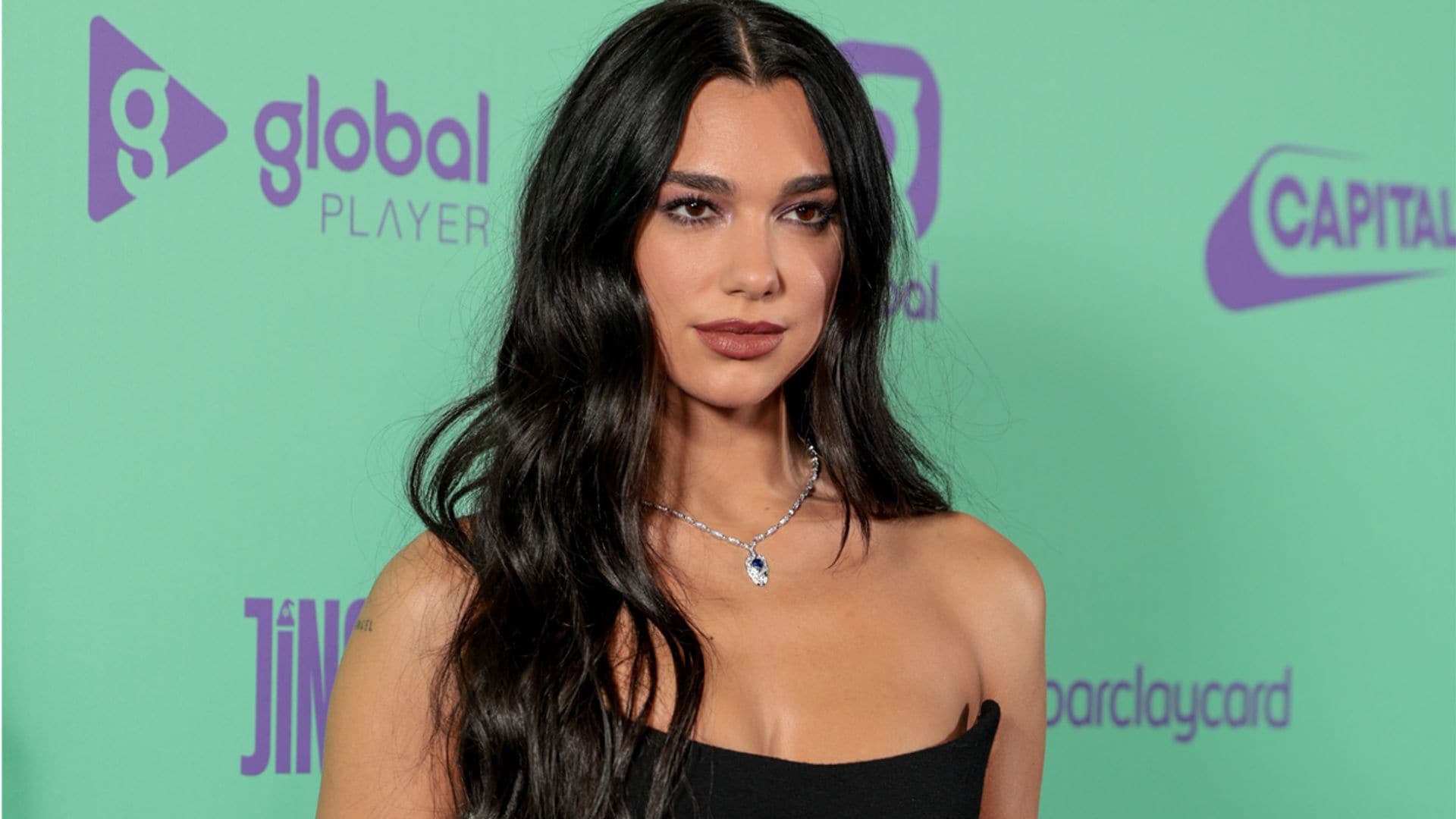 Dua Lipa lo confirma: las medias son el mejor complemento para tu minivestido negro este invierno