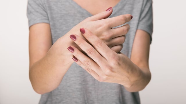 mujer sujetándose la mano para evitar que le tiemble