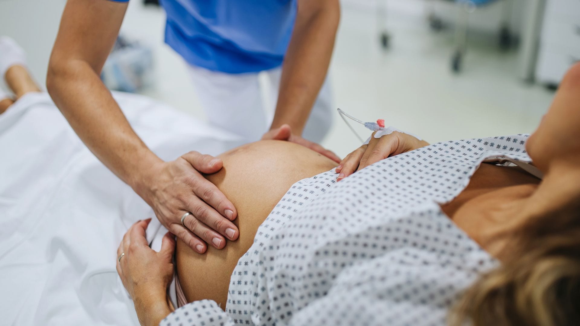 Obstreta examina el vientre de una mujer embarazada