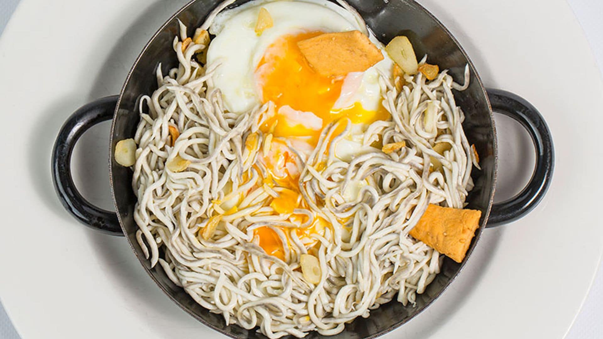 Sartén de gulas con puerro y huevos rotos