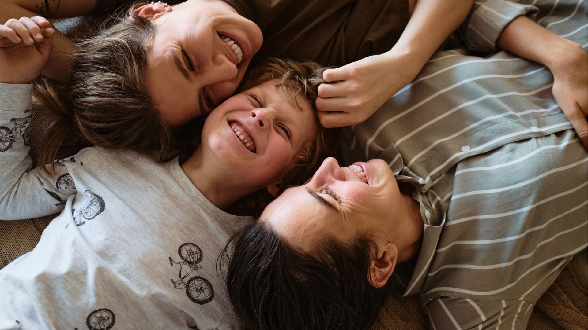 madres con su hijo en la cama sonriendo 