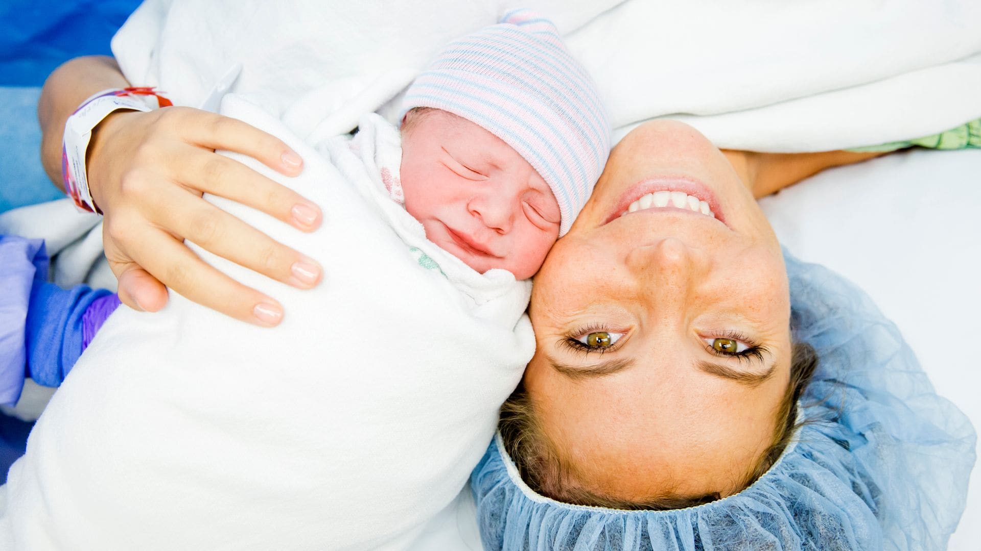 Madre sonriendo después de que su hijo haya nacido por cesárea