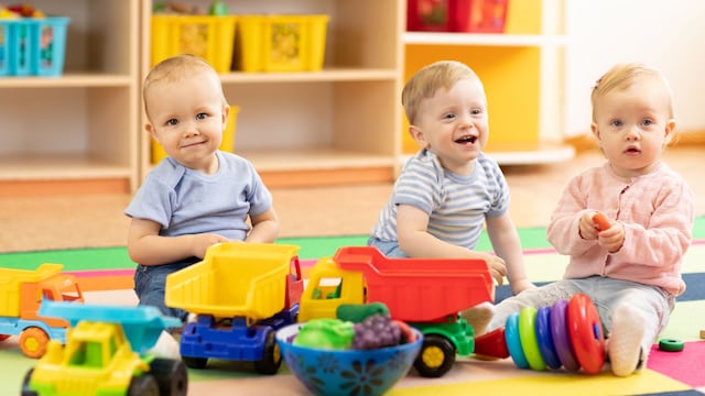 Bebés sentados jugando en el escuela infantil