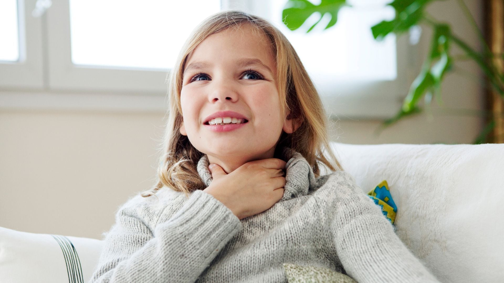 Niña se toca la garganta con gesto de dolor