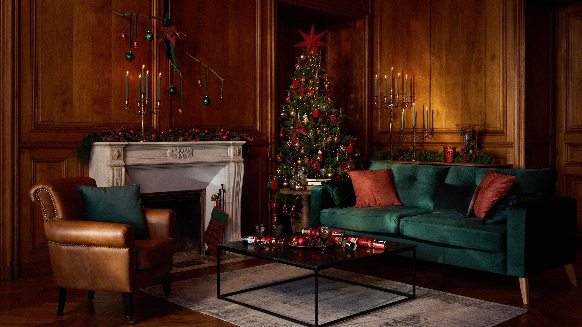 Salón con chimenea, árbol de Navidad, sofá verde de terciopelo y candelabros 