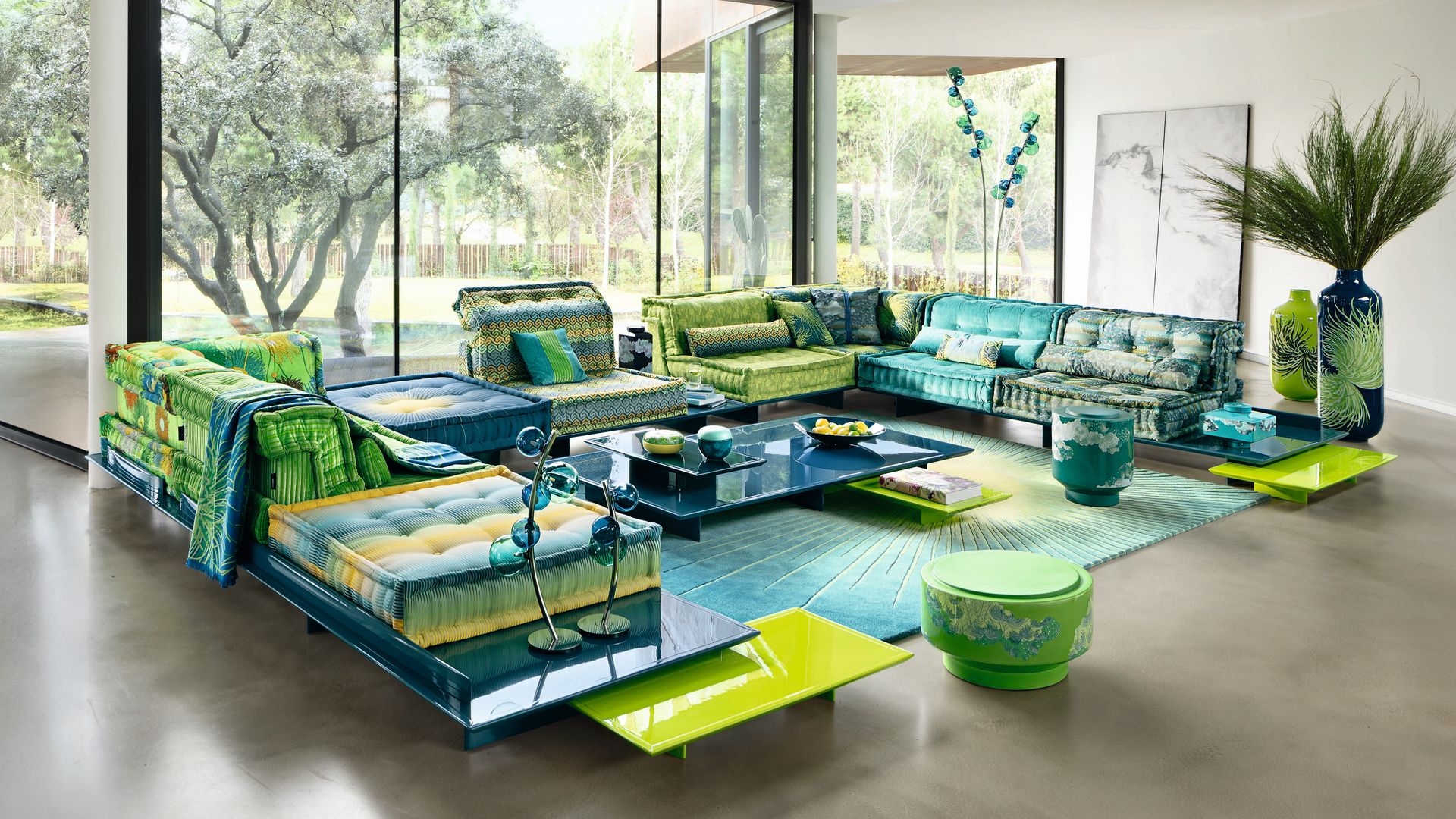 Salón XL con grandes ventanales y sofá Max Jong de Roche Bobois en verde y azules 