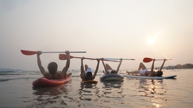 Grupo de amigos en tablas de 'paddle surf' en la playa en verano