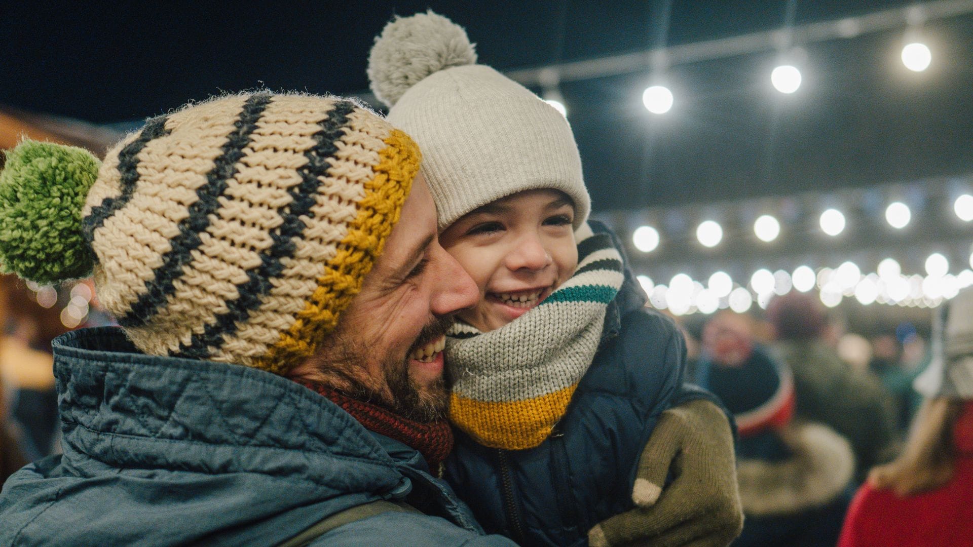 Padre e hijo, felices en un mercado navideño