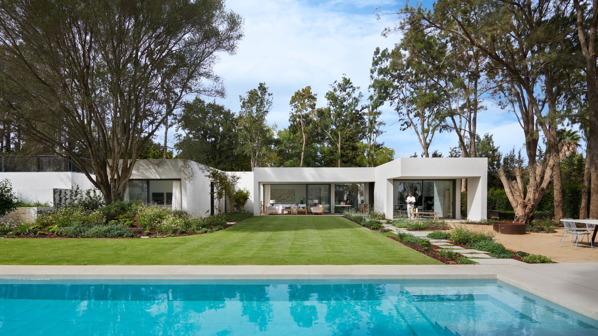 Casa prefabricada moderna con grandes ventanales, piscina y jardín