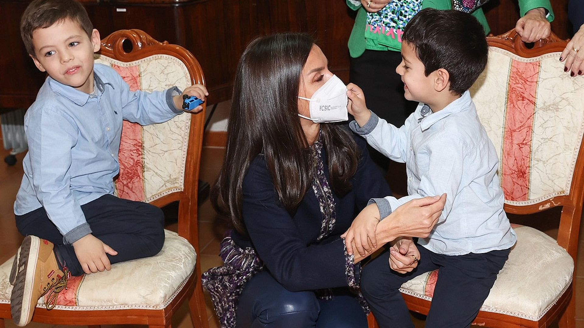 La Reina, al piano, muestra su imagen más cariñosa con unos niños: '¿Sabes tocarlo?'