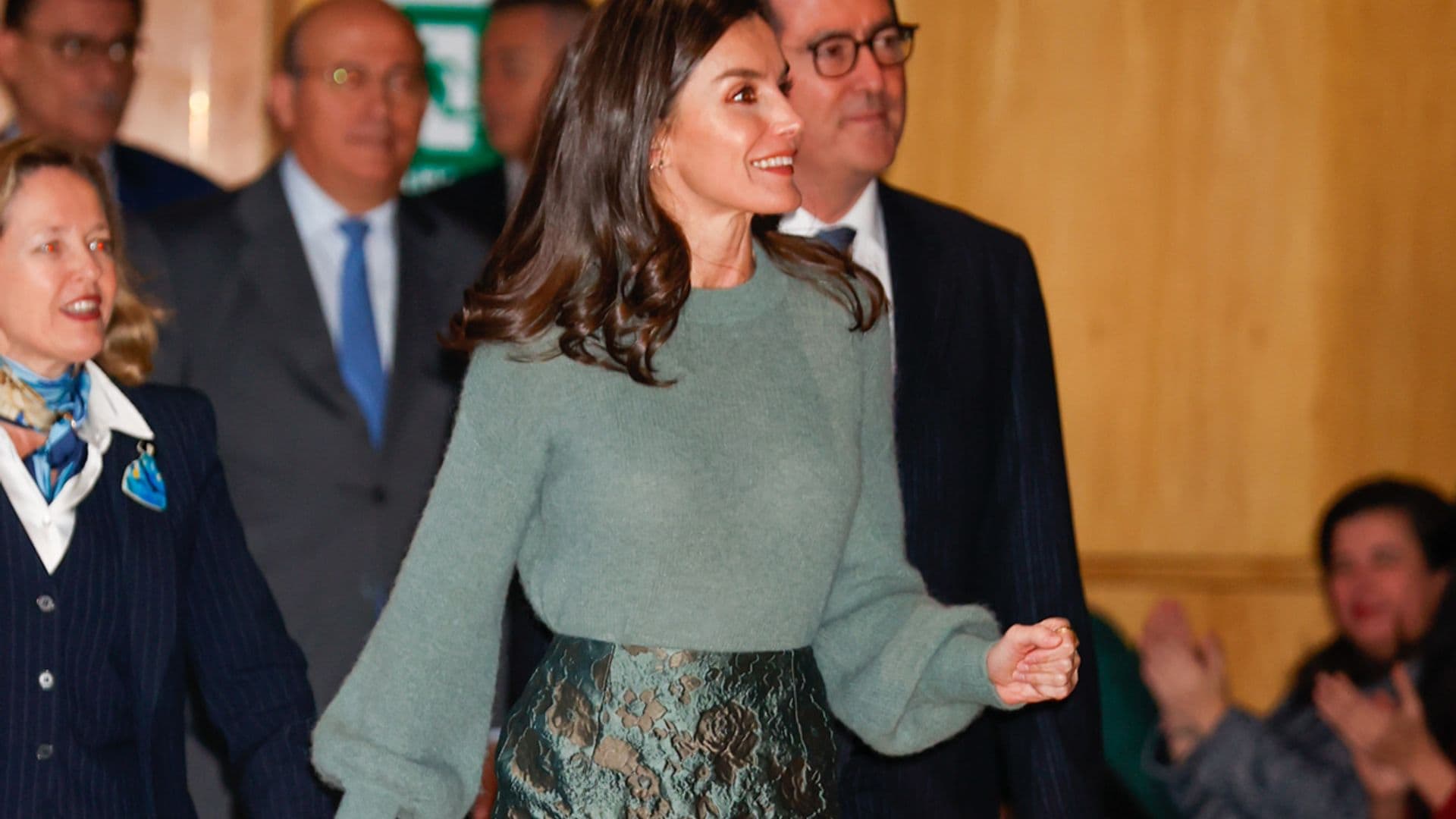 La Reina recicla su look de invitada más versátil: jersey calentito y falda brocada de flores