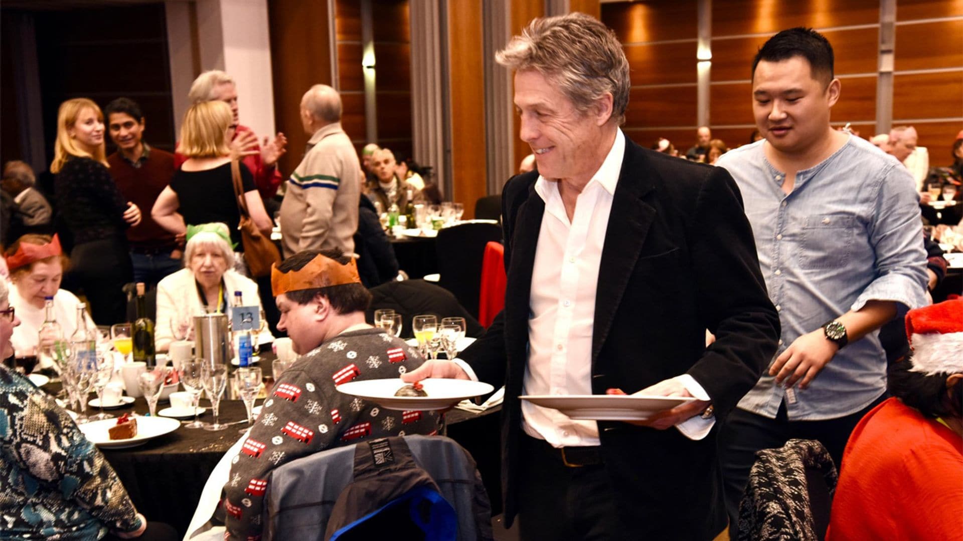 Hugh Grant sorprende sirviendo una cena de Navidad a 500 ancianos de una pequeña localidad de Londres