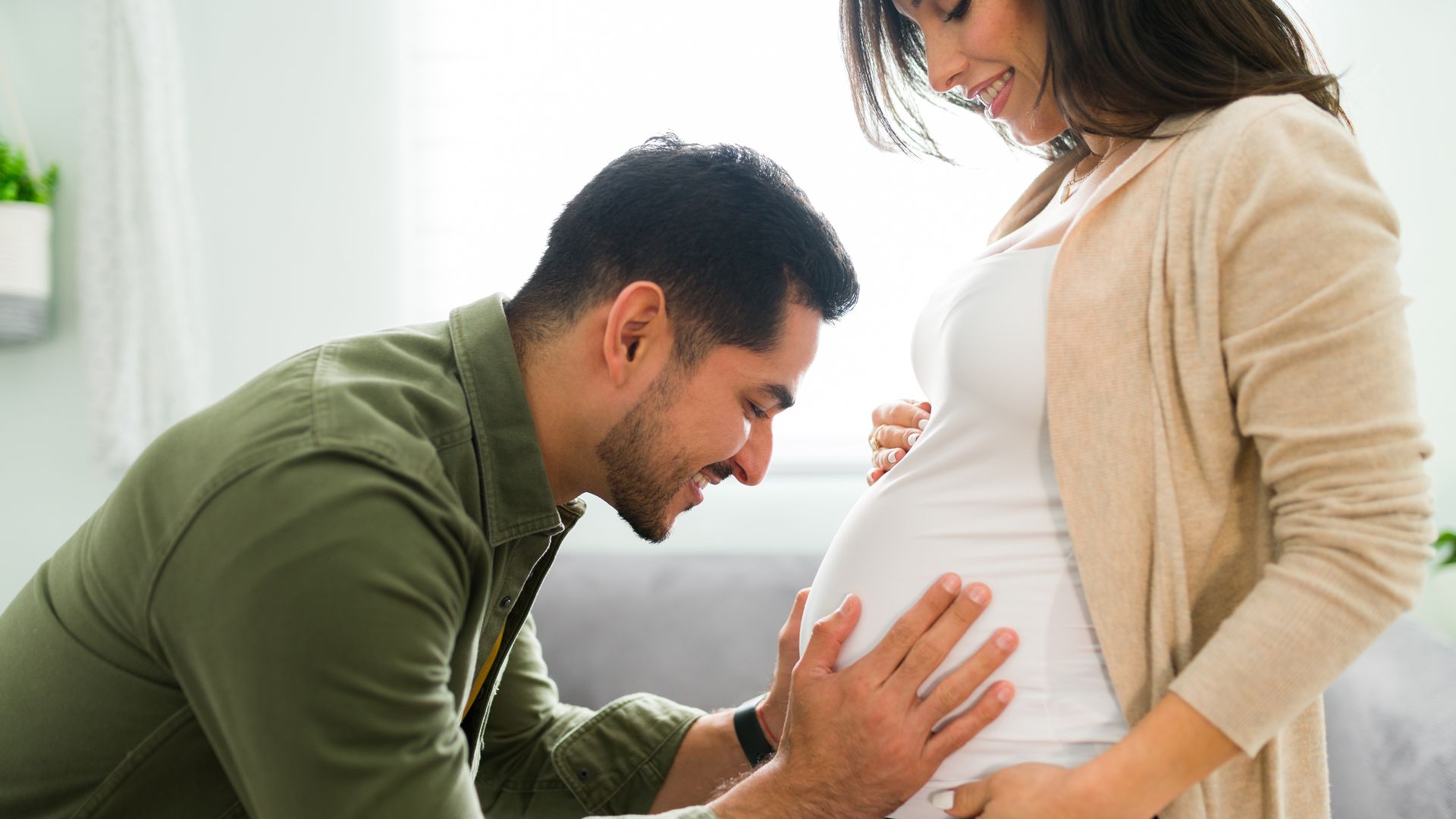 Marido abraza el vientre de su mujer, embarazada