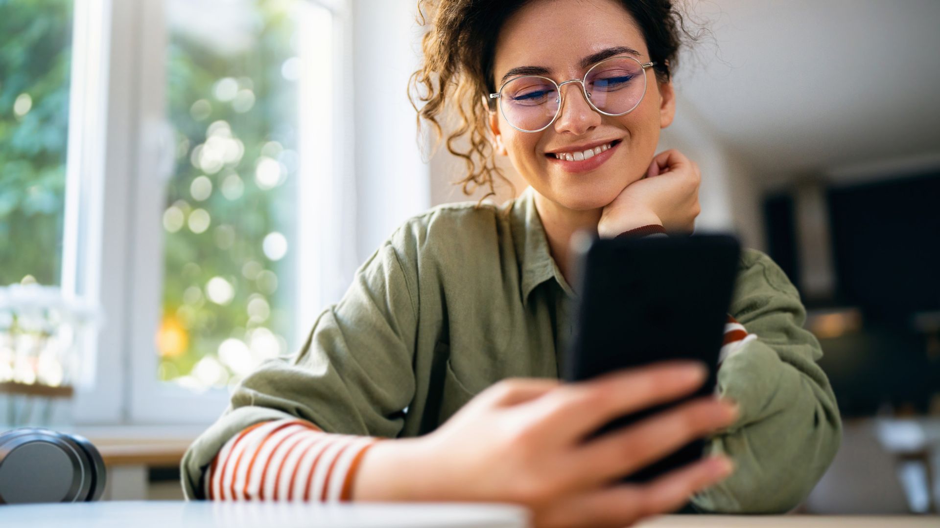 Una mujer con gafas usando su teléfono