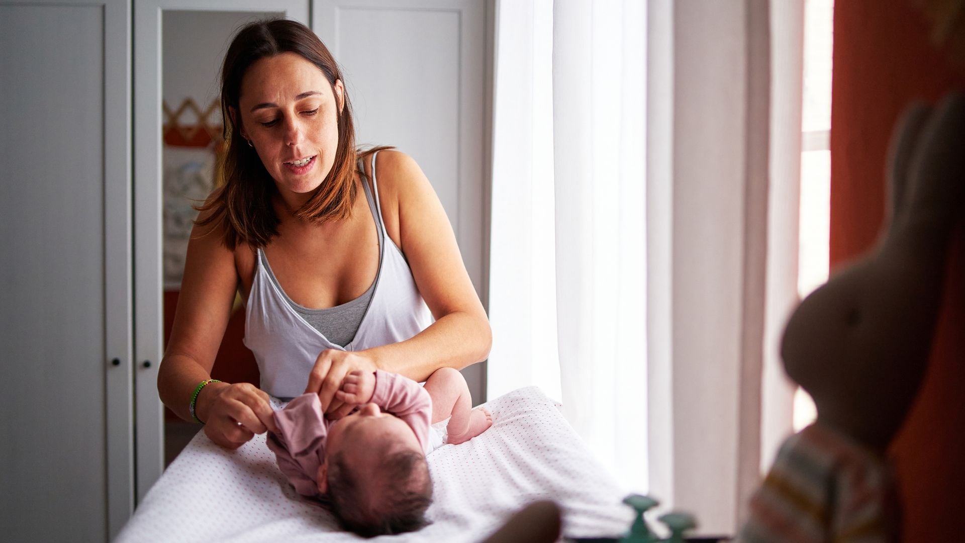 Madre cambia el pañal a su hija recién nacida