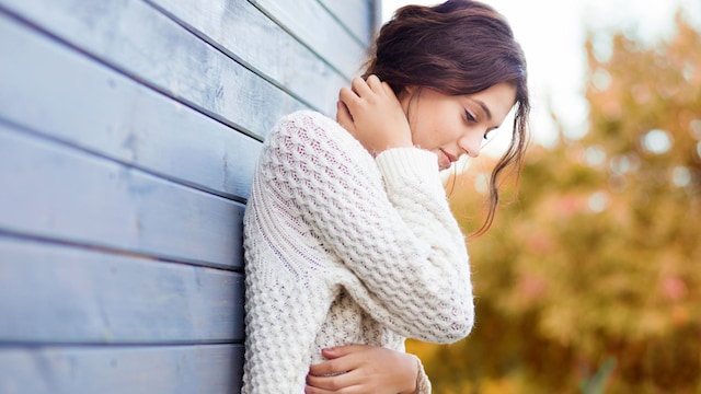 mujer pensativa apoyada en la pared