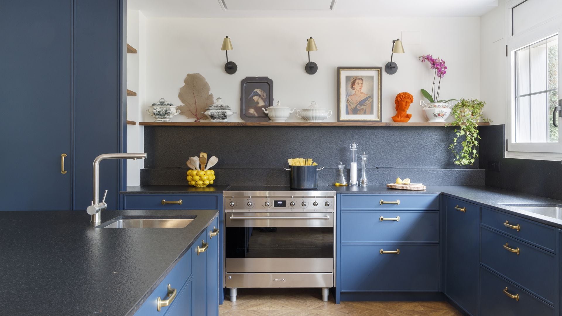 Cocina con muebles en azul y focos en la pared