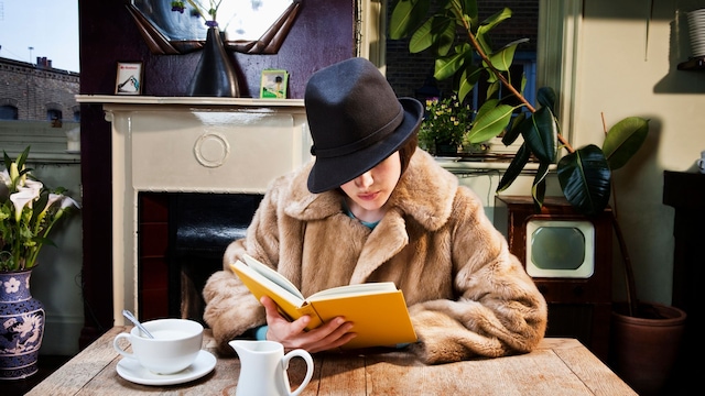 Mujer leyendo un libro en un café