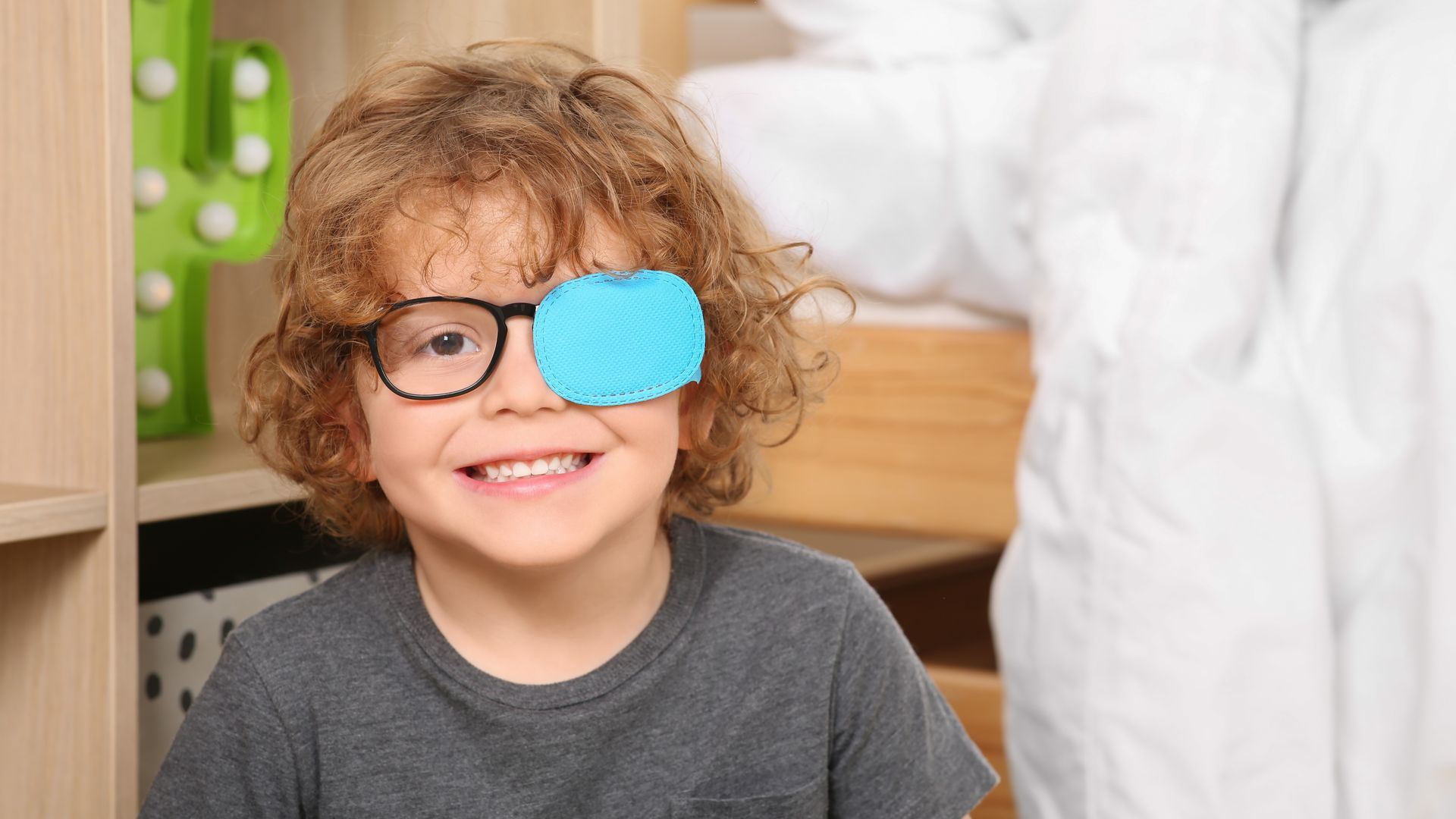 Niño con estrabismo lleva gafas y parche en un ojo