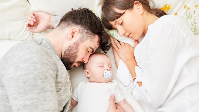 Pareja duerme con su bebé