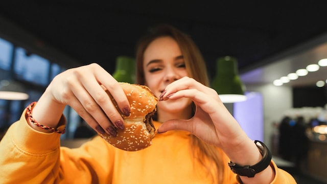 adolescente comiendo comida basura