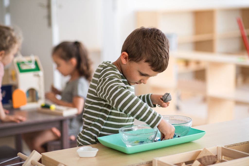 Niño haciendo experimentos con agua en una clase Montessori