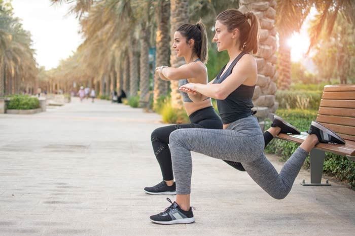 mujer haciendo ejercicio en un banco del parque