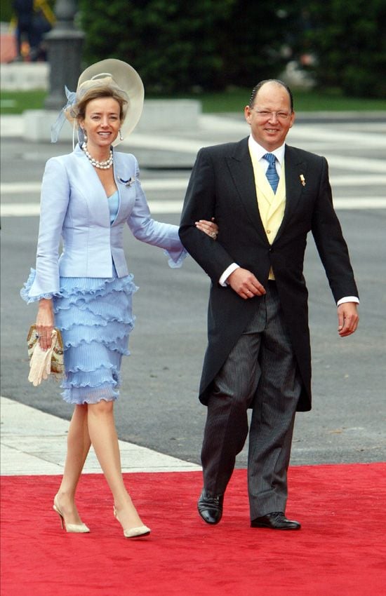 Kardam de Bulgaria y su mujer en la boda de don Felipe y doña Letizia celebrada en mayo de 2004. Para aquella ocasión, Miriam llevaba un diseño de Eduardo Ladrón de Guevara, compuesto de traje con chaqueta en seda tramada y falda de gasa natural en plisado 'soley' escamado. Además, lució un tocado con ala y visera grande en azul y arena, confeccionado con sisal, gasa y plumas. Como complementos, eligió un bolso de mano antiguo de principios de siglo XX en 'petit point' con cristales, un maravilloso collar de perlas y broche en forma de águila con brillantes, lacas y lapislázuli. Todos estos complementos pertenecen a la familia Ungría
