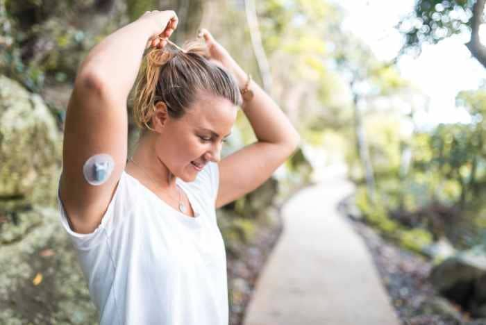 mujer deportista con medidor de glucosa en su brazo