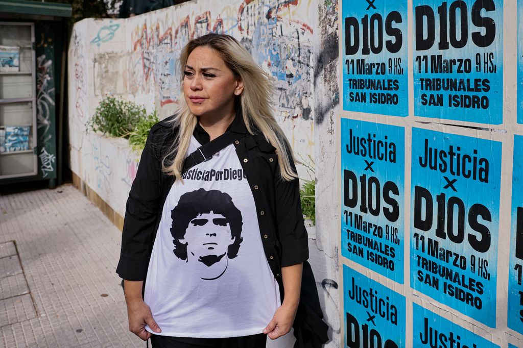 Verónica Ojeda, exesposa de Diego Maradona, posa frente a carteles que exigen justicia por la muerte del astro argentino