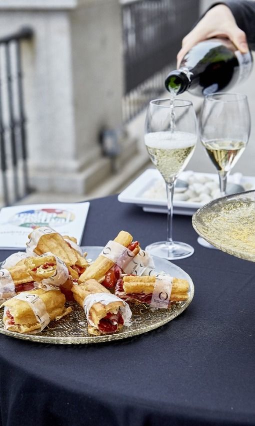 Bocatín de jamón ibérico, tomate y pan de cristal junto a dos copas de vino blanco en el Teatro Real de Madrid