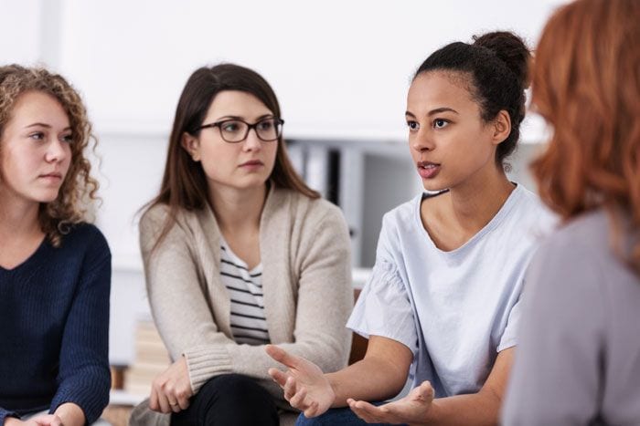 mujeres hablando en grupo