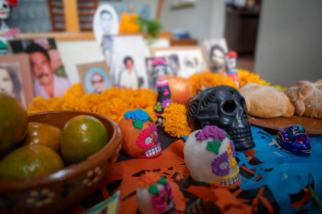 Retratos e imágenes religiosas en un altar de día de los muertos