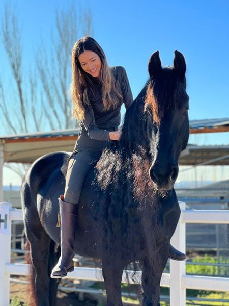 Malena Costa acariciando a su caballo 